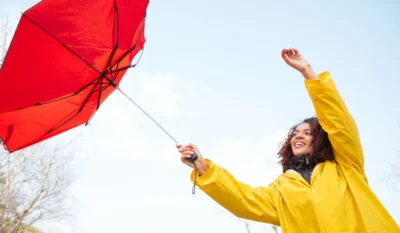 Ветренная погода, девушка в желтом с красным зонтом